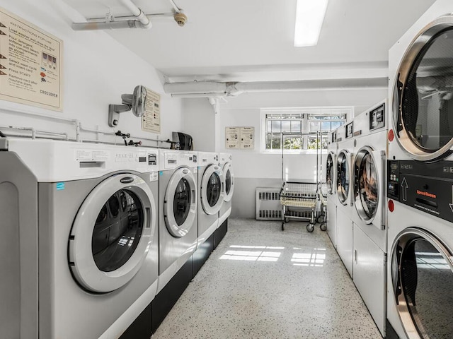 clothes washing area featuring washing machine and dryer, stacked washer and dryer, and radiator