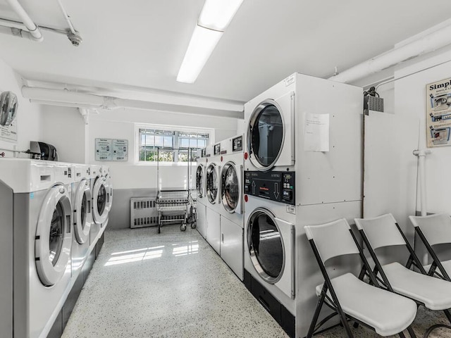 laundry area with radiator heating unit and stacked washer and clothes dryer