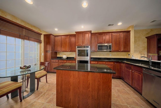 kitchen with sink, appliances with stainless steel finishes, decorative backsplash, a kitchen island, and ornamental molding