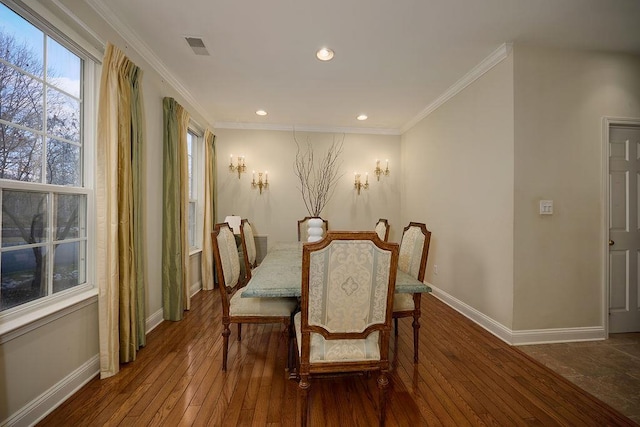 dining area with wood-type flooring and crown molding