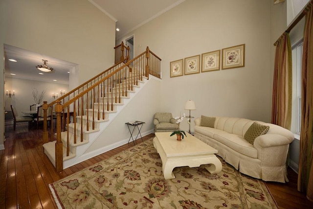 living room featuring dark hardwood / wood-style floors, ornamental molding, and a high ceiling