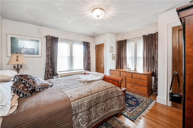 bedroom with wood-type flooring and multiple windows