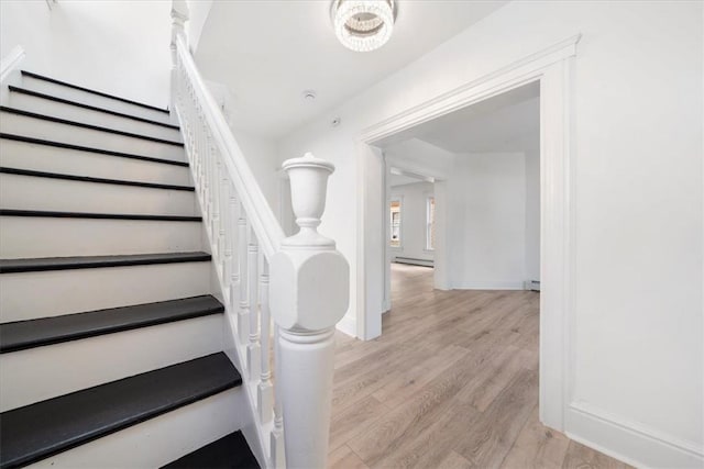 stairway featuring baseboard heating and hardwood / wood-style flooring