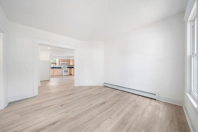 unfurnished room with light wood-type flooring and a baseboard heating unit