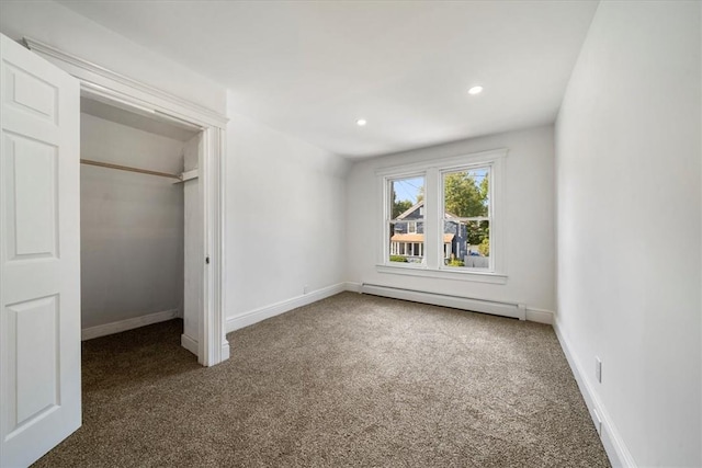 unfurnished bedroom featuring dark carpet, a closet, and a baseboard radiator