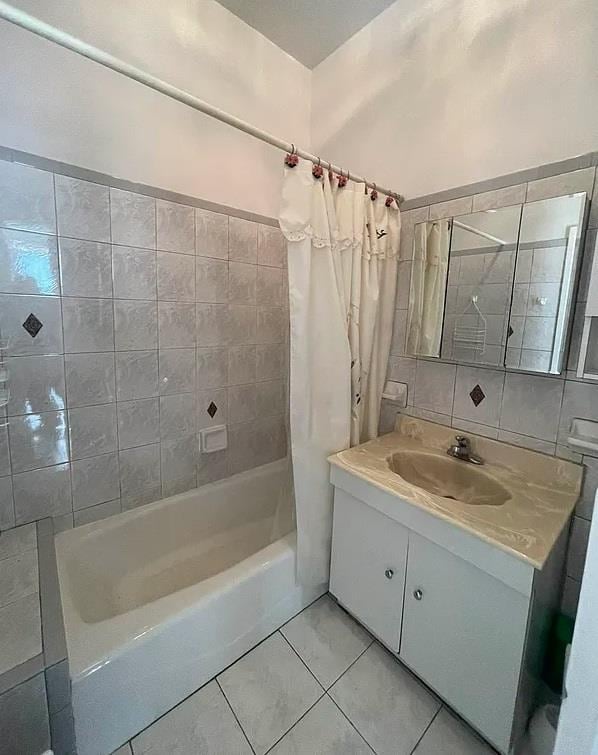 bathroom with tasteful backsplash, shower / bath combo with shower curtain, and vanity