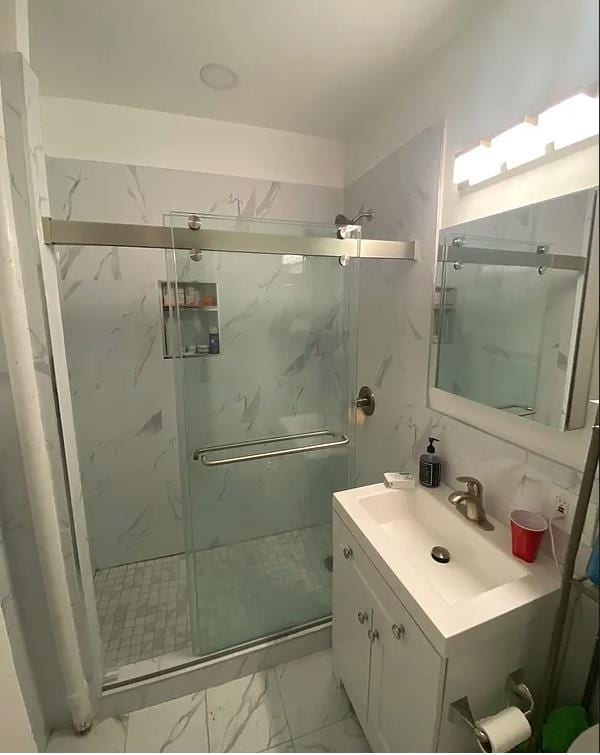 bathroom featuring vanity and a shower with shower door