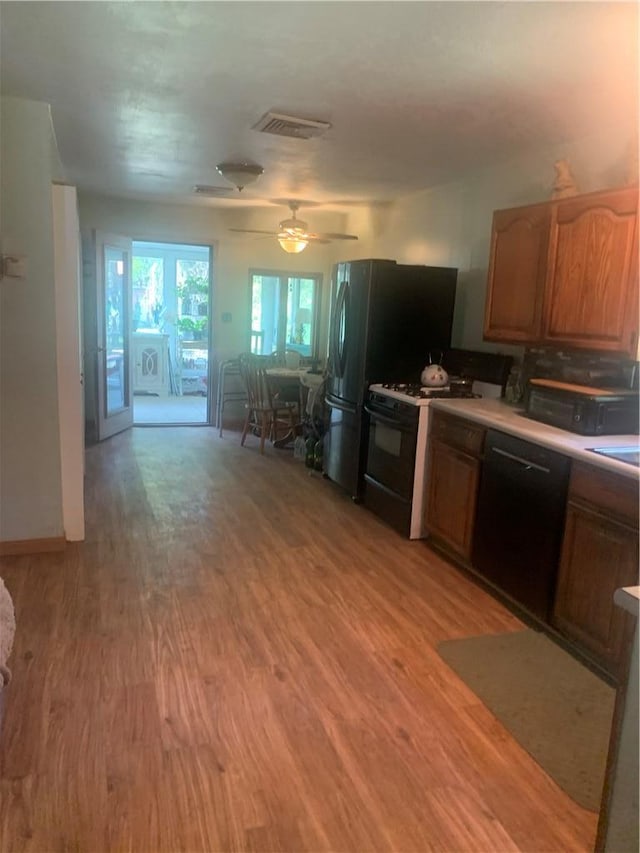 kitchen featuring dishwasher, wood-type flooring, ceiling fan, and white gas stove