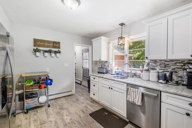 kitchen featuring backsplash, white cabinets, sink, light hardwood / wood-style flooring, and stainless steel dishwasher