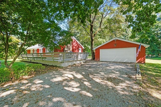 view of yard featuring a garage, an outbuilding, and a wooden deck