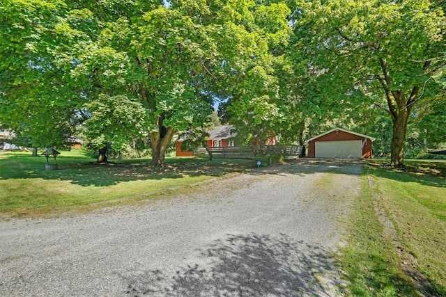 view of front facade with a front yard, an outdoor structure, and a garage