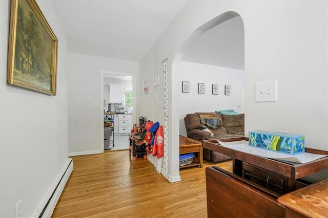 living room with light wood-type flooring and a baseboard heating unit