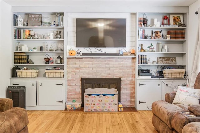 living room featuring a fireplace and light wood-type flooring