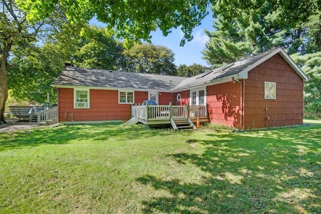 rear view of property with a deck and a yard