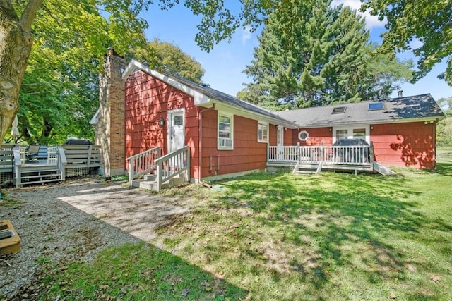 rear view of house with a yard and a wooden deck