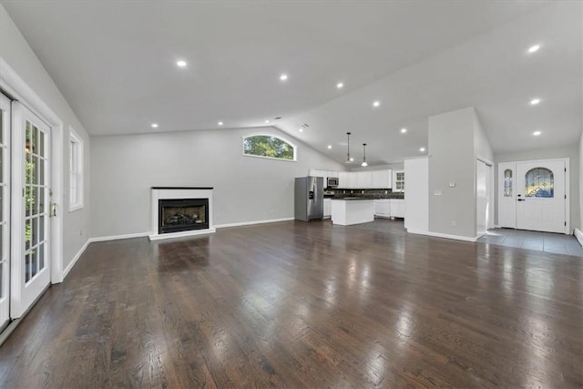 unfurnished living room with dark hardwood / wood-style flooring and vaulted ceiling