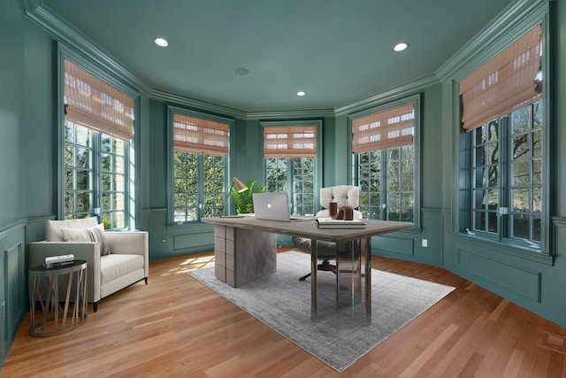 home office featuring visible vents, a decorative wall, crown molding, and wood finished floors