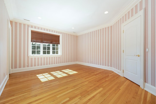 unfurnished room featuring wallpapered walls, light wood-style flooring, and ornamental molding