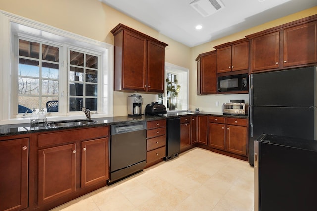 kitchen featuring visible vents, a sink, dark stone counters, plenty of natural light, and black appliances