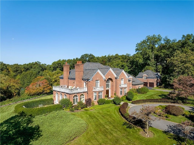 778 Sleepy Hollow Rd, Briarcliff Manor, NY 10510 - colonial home featuring a balcony, a chimney, a front lawn, brick siding, and driveway