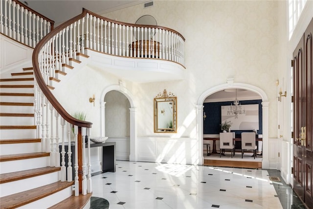 778 Sleepy Hollow Rd, Briarcliff Manor, NY 10510 - tiled entrance foyer with a towering ceiling, arched walkways, stairs, a decorative wall, and a wainscoted wall