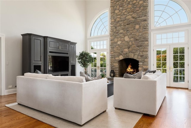 778 Sleepy Hollow Rd, Briarcliff Manor, NY 10510 - living area featuring french doors, a high ceiling, light wood-style flooring, and a stone fireplace