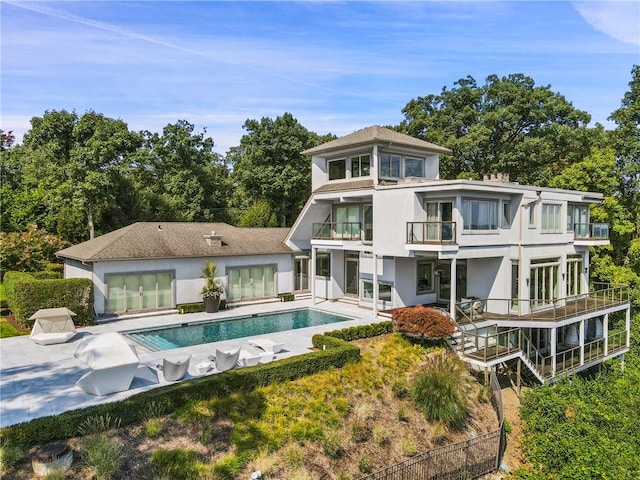 back of property featuring a balcony and a patio