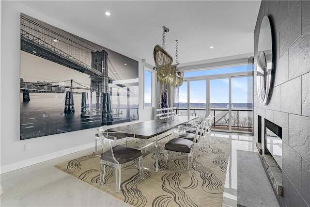 dining space featuring a chandelier and a tiled fireplace