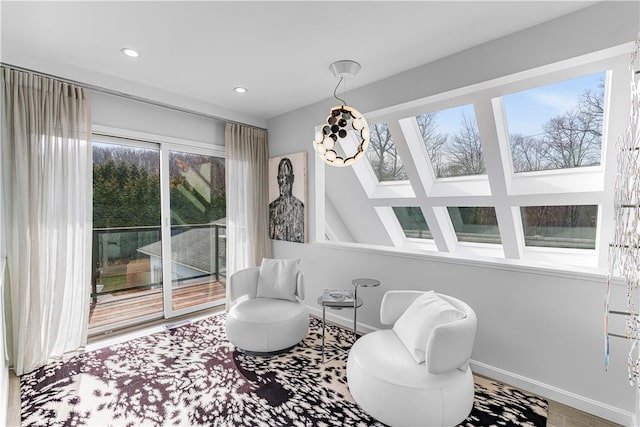 living area with hardwood / wood-style floors, a wealth of natural light, and vaulted ceiling