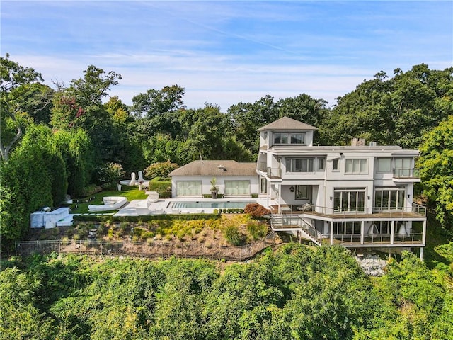 rear view of property featuring a patio area and a balcony