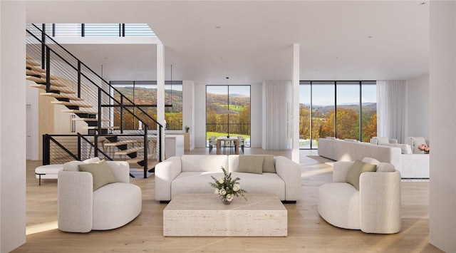 sunken living room with light wood-style flooring, expansive windows, stairway, and a mountain view