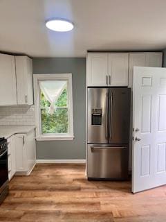 kitchen featuring white cabinets, light hardwood / wood-style floors, and stainless steel refrigerator with ice dispenser