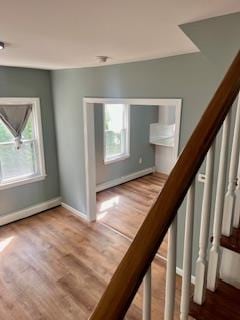 stairs featuring hardwood / wood-style flooring and a healthy amount of sunlight