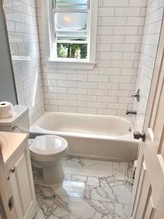 full bathroom featuring vanity, toilet, and tiled shower / bath