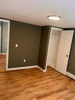 unfurnished bedroom with light hardwood / wood-style floors and a closet