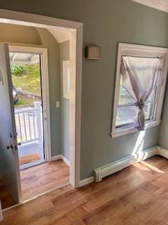 doorway to outside with light hardwood / wood-style flooring and a baseboard heating unit