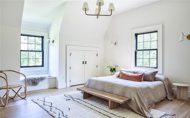 bedroom featuring multiple windows, hardwood / wood-style floors, and vaulted ceiling