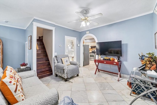 living room featuring arched walkways, stairway, a ceiling fan, and crown molding