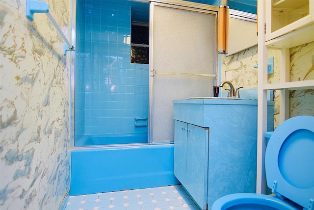 bathroom with tile patterned flooring, sink, and bath / shower combo with glass door