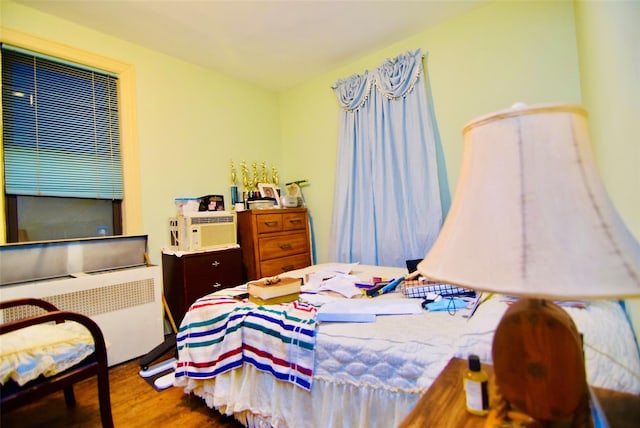 bedroom featuring radiator and hardwood / wood-style floors