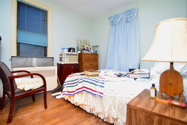 bedroom with wood-type flooring and radiator