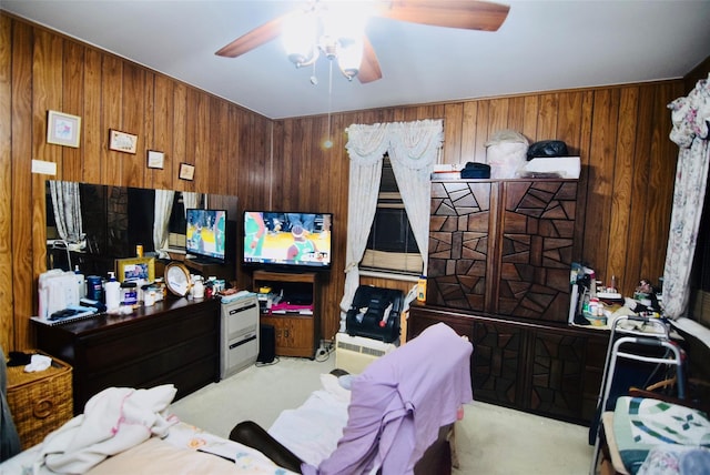 bedroom with light colored carpet, ceiling fan, and wood walls