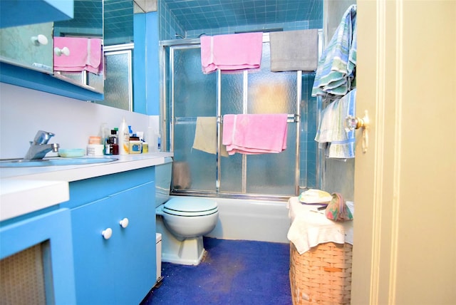 full bathroom with enclosed tub / shower combo, vanity, and toilet