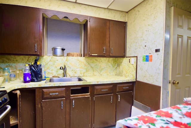 kitchen with dark brown cabinetry, sink, and backsplash