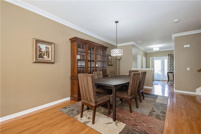 dining room with hardwood / wood-style floors, french doors, and ornamental molding