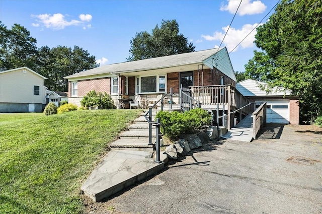 view of front facade featuring covered porch, an outbuilding, a garage, and a front lawn