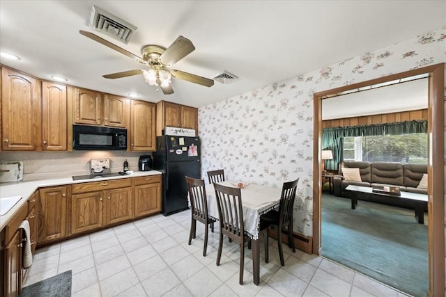 kitchen with black appliances, ceiling fan, and light colored carpet