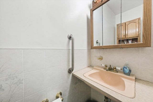 bathroom with sink and tile walls