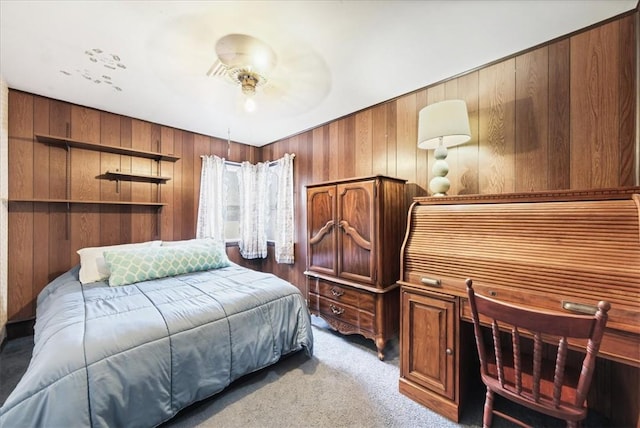 bedroom featuring ceiling fan, light carpet, and wooden walls