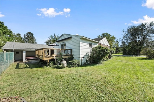 rear view of property with a wooden deck and a yard